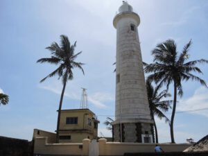 a lighthouse with palm trees