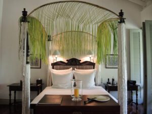 a bed with a table and a glass of orange juice