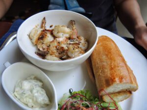 a plate of food with a bowl of shrimp and bread