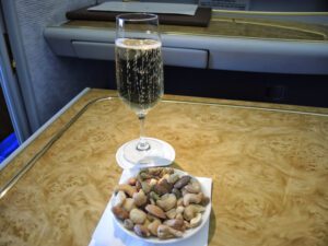a glass of champagne and a bowl of nuts