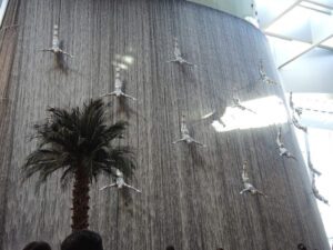 a waterfall with people jumping into the air