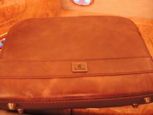 a brown leather bag on a wood surface