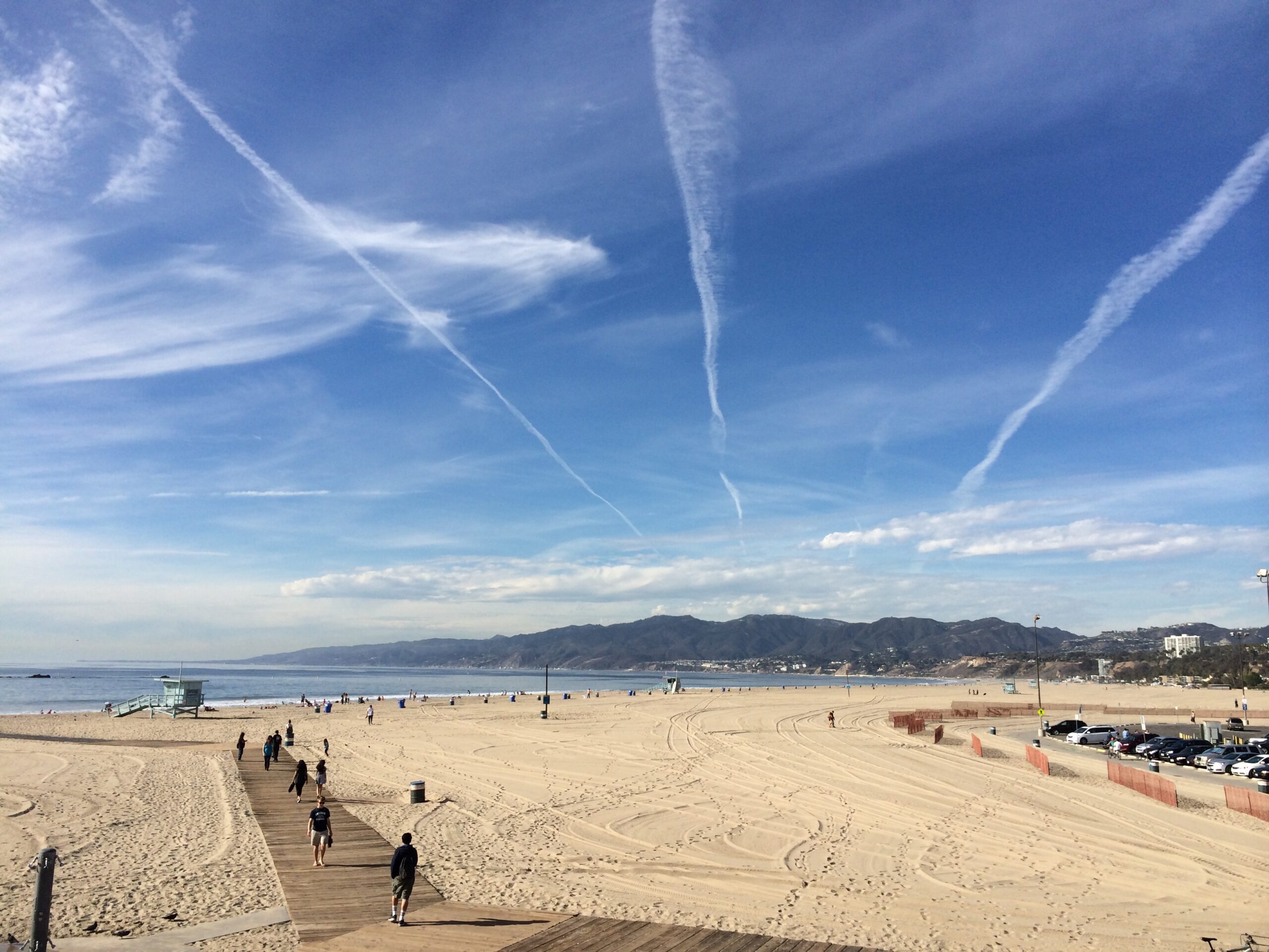 a beach with people walking on sand