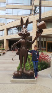 a man standing next to a statue of a rabbit