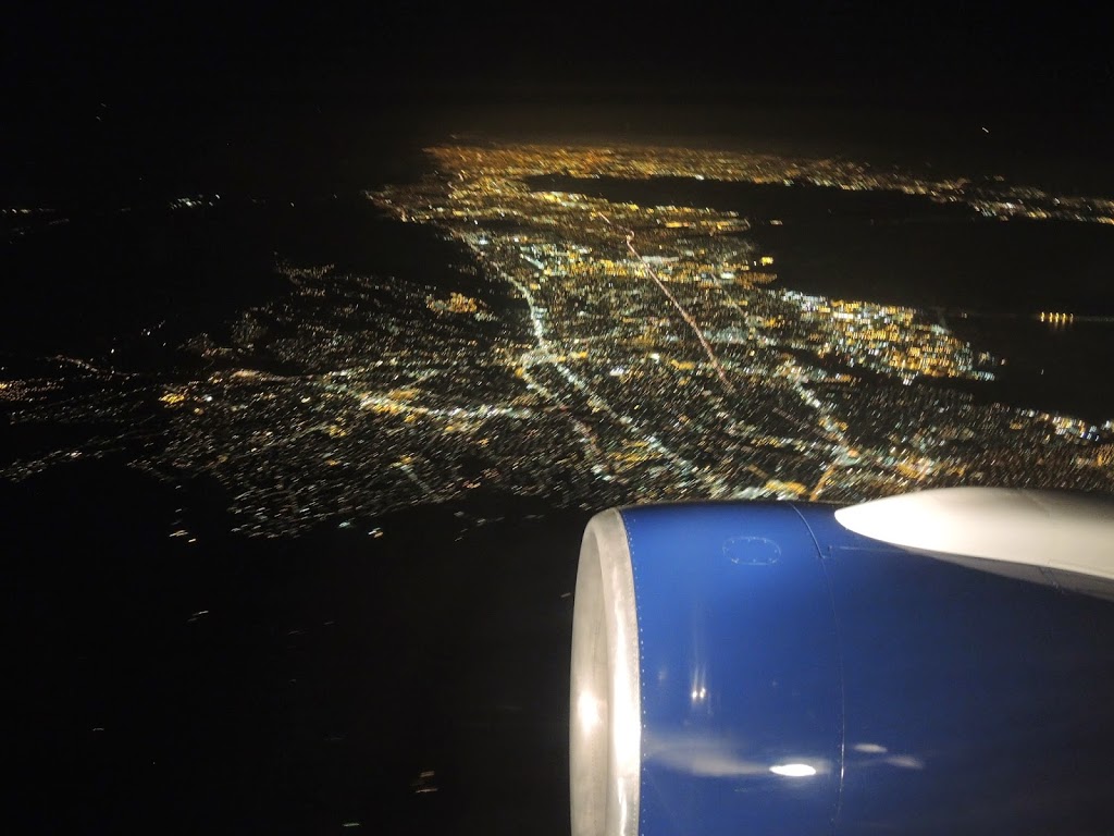 an airplane wing and a city at night