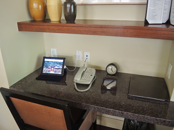 a desk with a phone and a clock on it