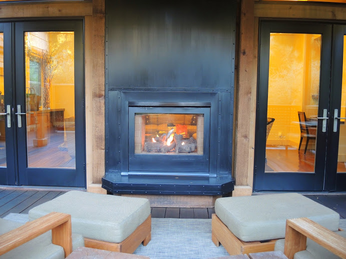 a fireplace with chairs and a table