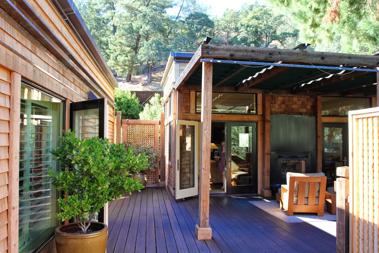 a deck with a patio and a tree in the back