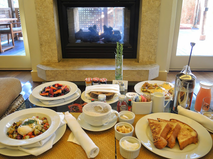 a table with plates of food and a fireplace