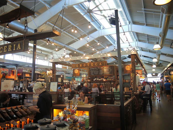 a large indoor market with people sitting at tables