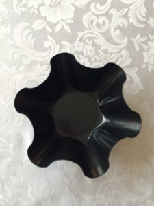 a black bowl on a white surface