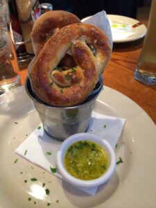 a pretzel in a bucket with sauce