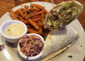 a plate of food with a burrito and fries