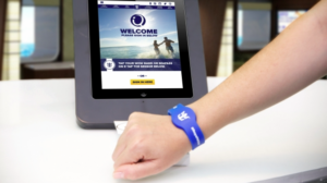 a hand with a blue wristband on a tablet
