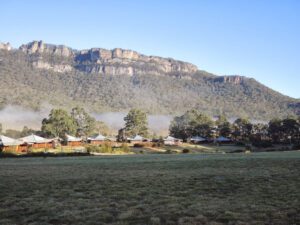a large grassy field with a mountain in the background
