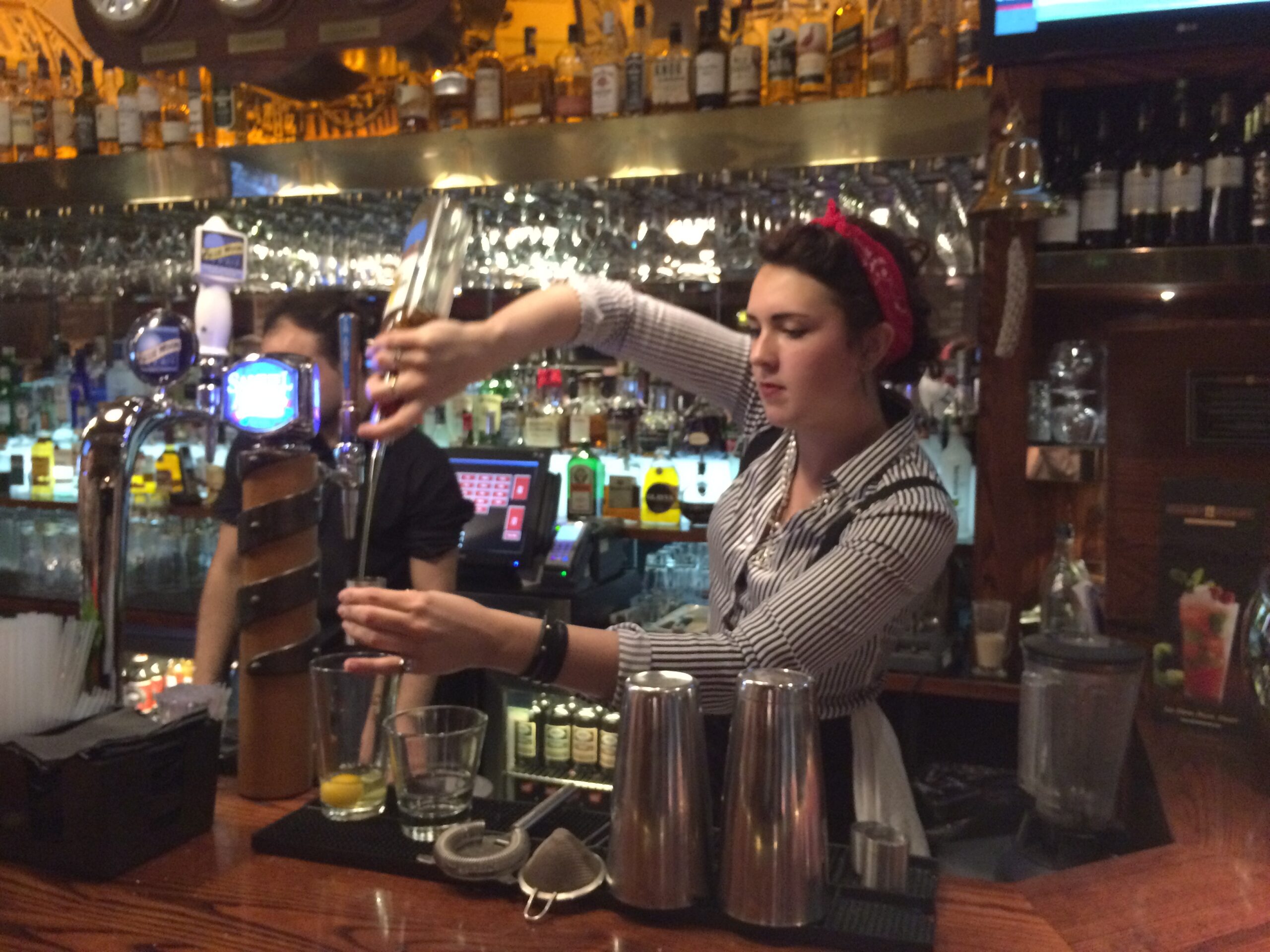 a woman pouring a drink into a glass