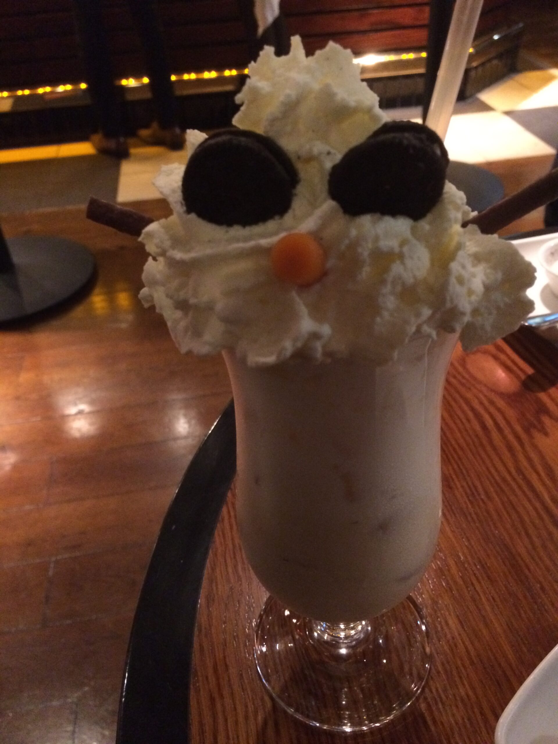 a glass with a snowman shaped ice cream and whipped cream