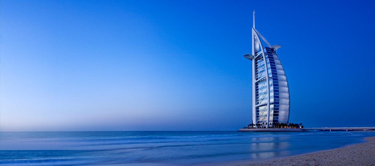 a tall building on a beach with Burj Al Arab in the background