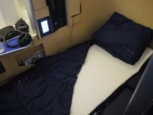 a bed with a blue blanket and a white sheet