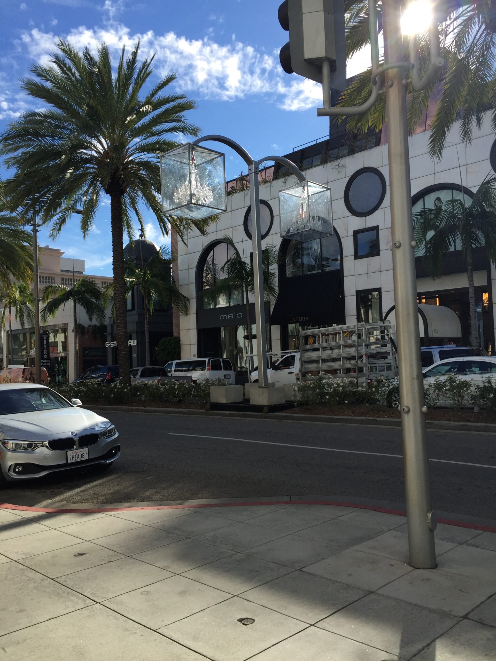 a street with palm trees and cars on the side