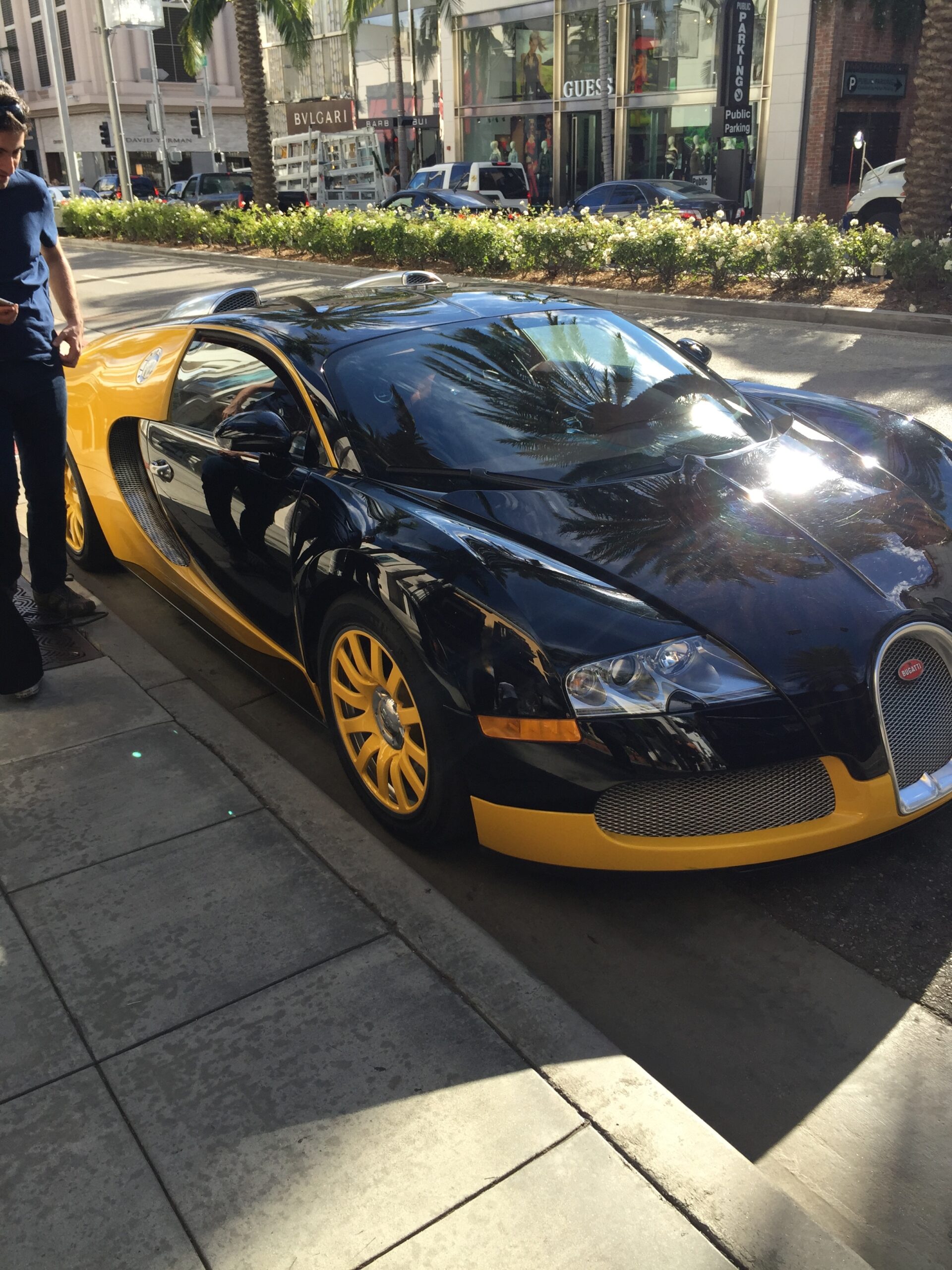 a black and yellow sports car parked on a sidewalk