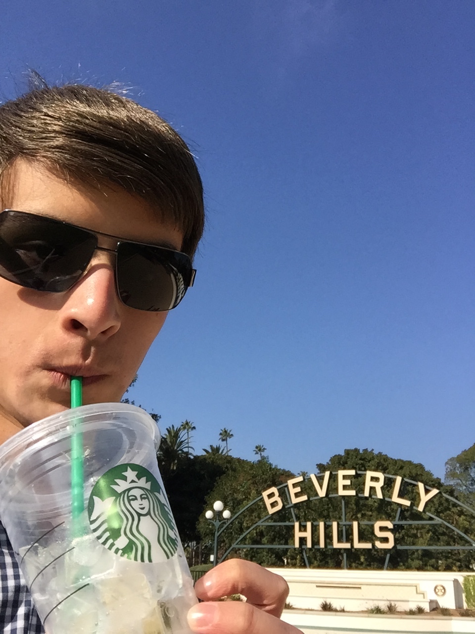 a man wearing sunglasses drinking from a cup