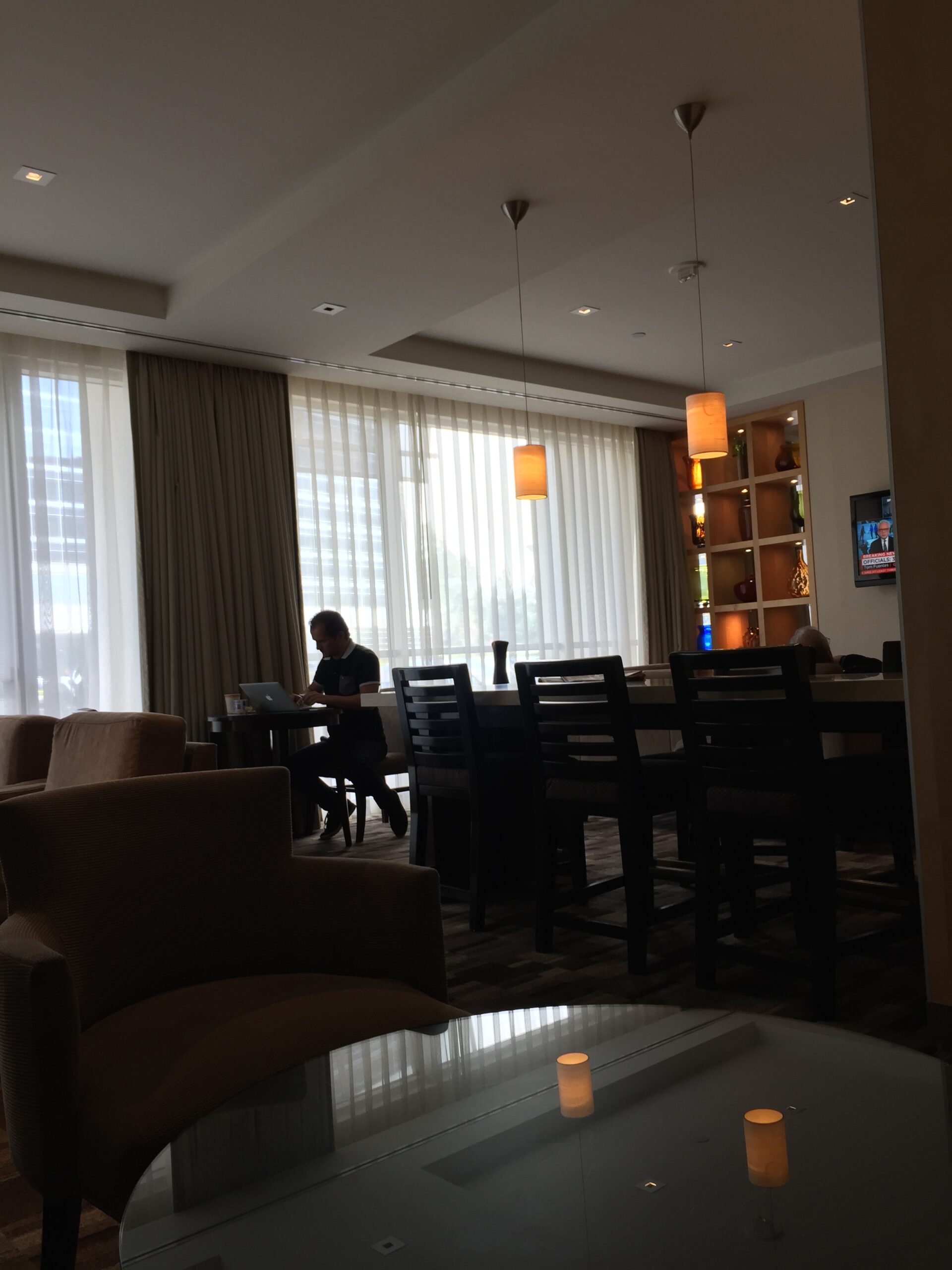 a man sitting at a table in a room with a laptop