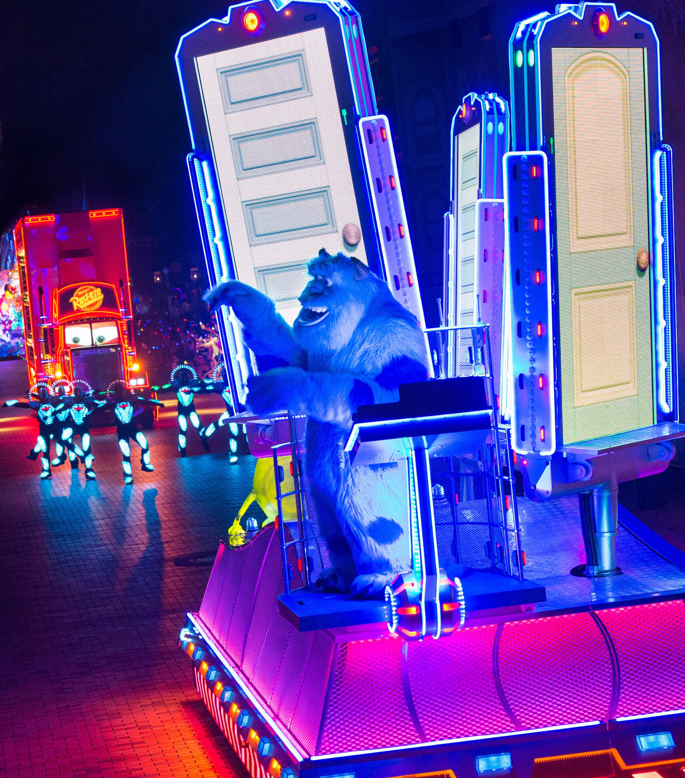 a large parade float with lights and people in the background