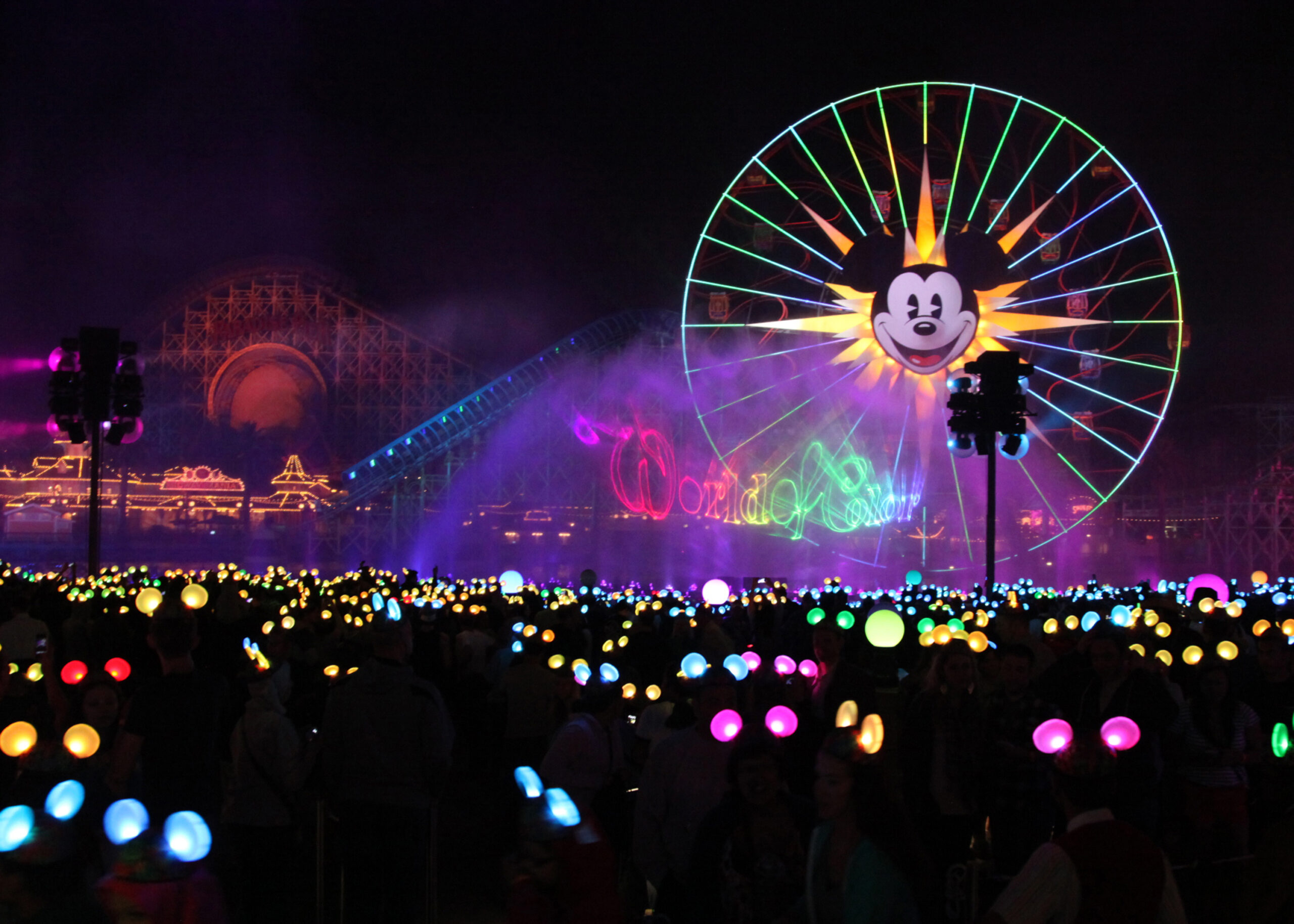 a large crowd of people with lights and a ferris wheel