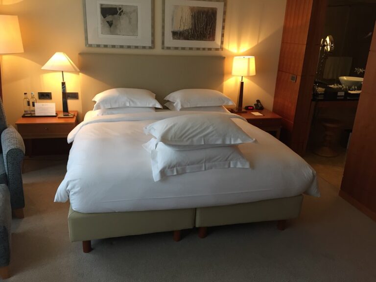 a bed with pillows and lamps in a room