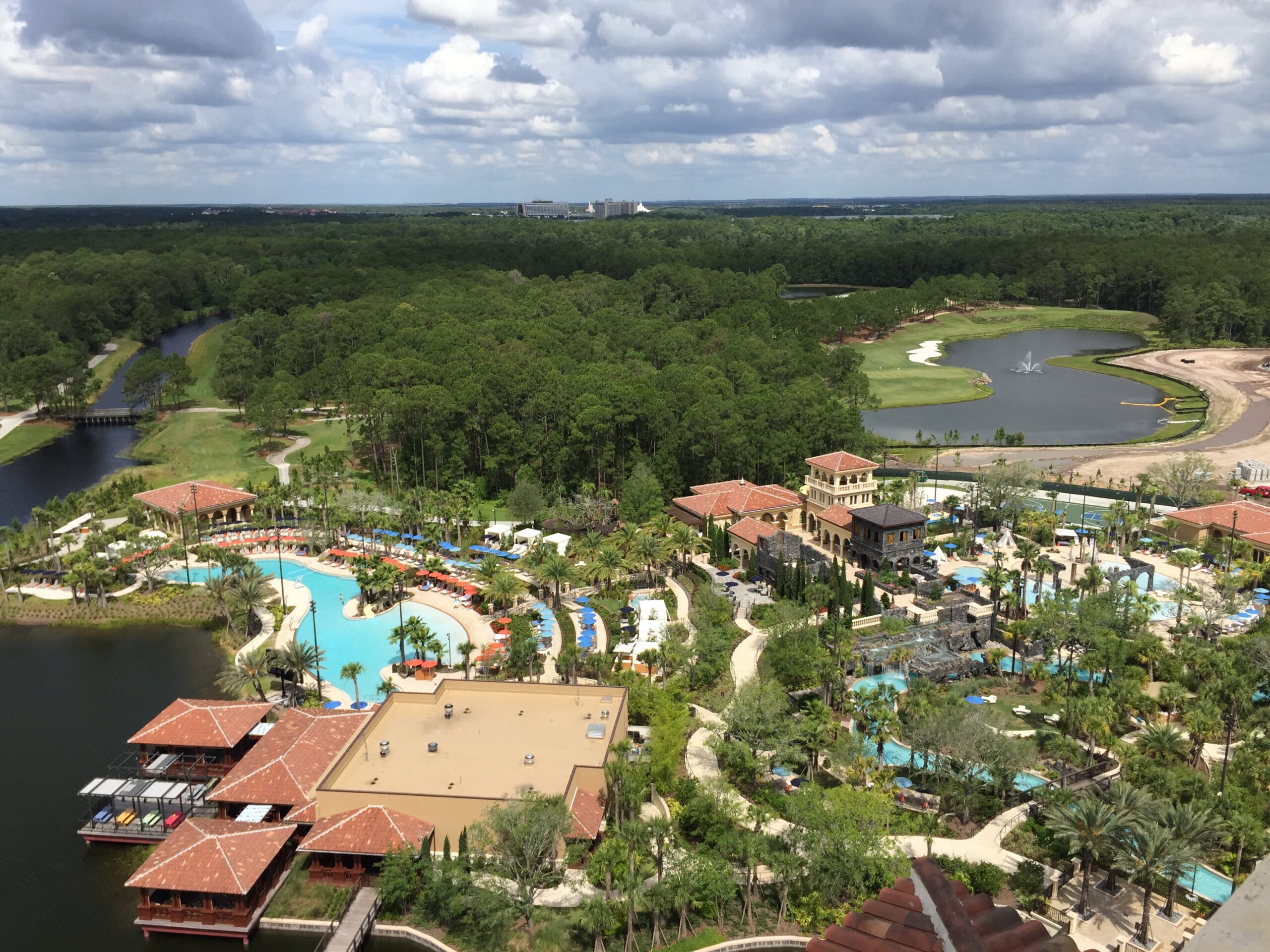 a aerial view of a resort with water pools and trees