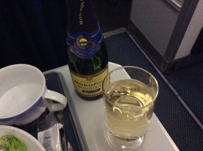 a bottle of champagne and a glass of wine on a tray