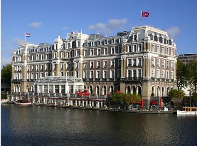 a large building with a river in the background