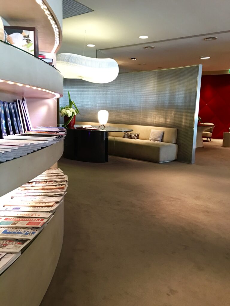 a room with a table and chairs and a table with magazines