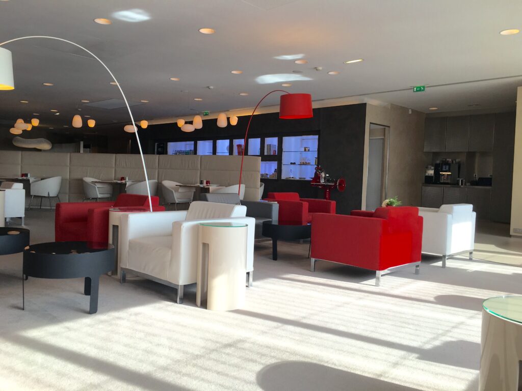 a room with a red and white couches and a lamp