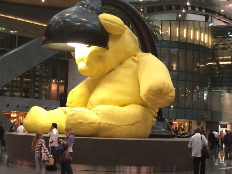 a large yellow stuffed animal statue in a building