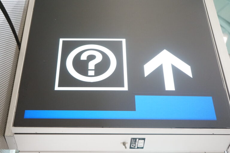 a sign with a question mark and arrow