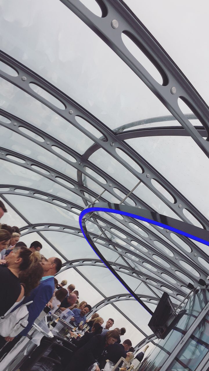 a group of people standing under a glass roof