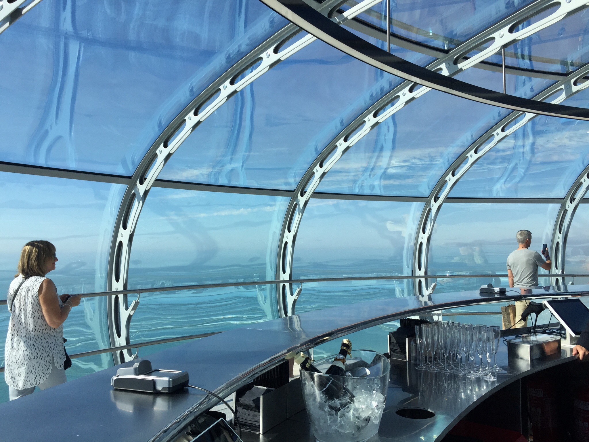 a glass dome with a bar and a glass bowl with glasses