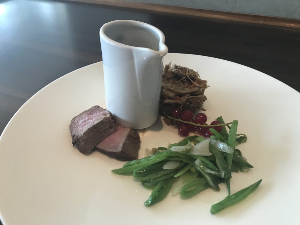 a plate of food with a white pitcher
