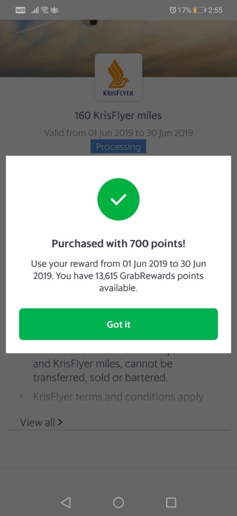 The image shows a mobile phone screen displaying a confirmation message for a purchase of 160 KrisFlyer miles using 700 points. The message indicates that the reward is valid from June 1, 2019, to June 30, 2019, and that the user has 13,615 GrabRewards points available. There is a green checkmark icon above the text "Purchased with 700 points!" and a "Got it" button at the bottom of the message. The background shows the KrisFlyer logo and some additional text about terms and conditions.