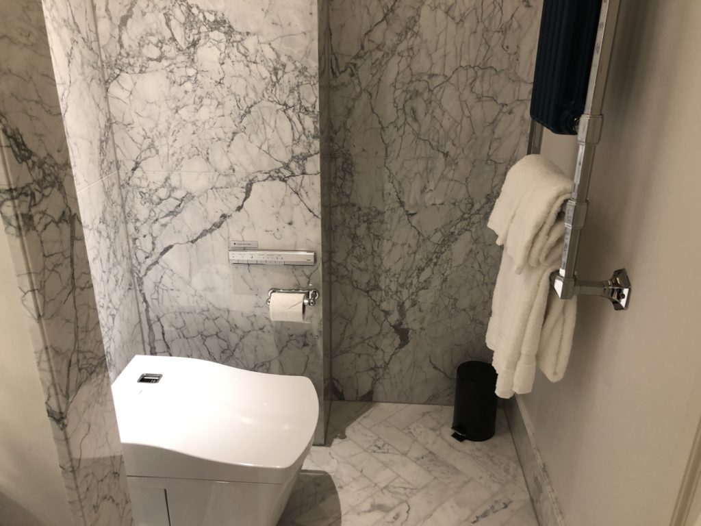 a bathroom with marble walls and a toilet