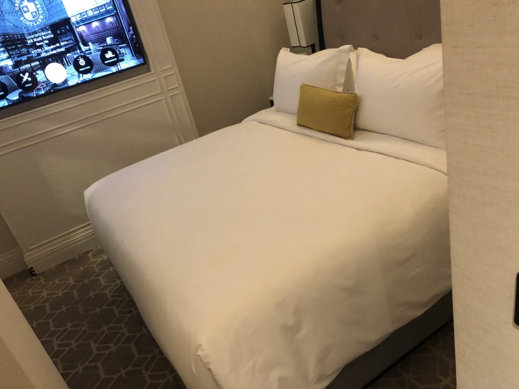 a bed with a pillow and a window