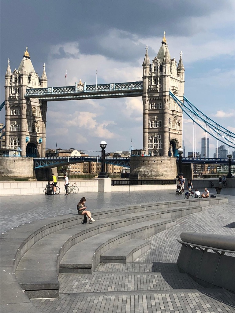 a bridge with people sitting on stairs